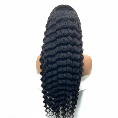 Black wavy hair wig on a mannequin head against a white background