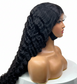 Black wig  on a mannequin head against a white background
